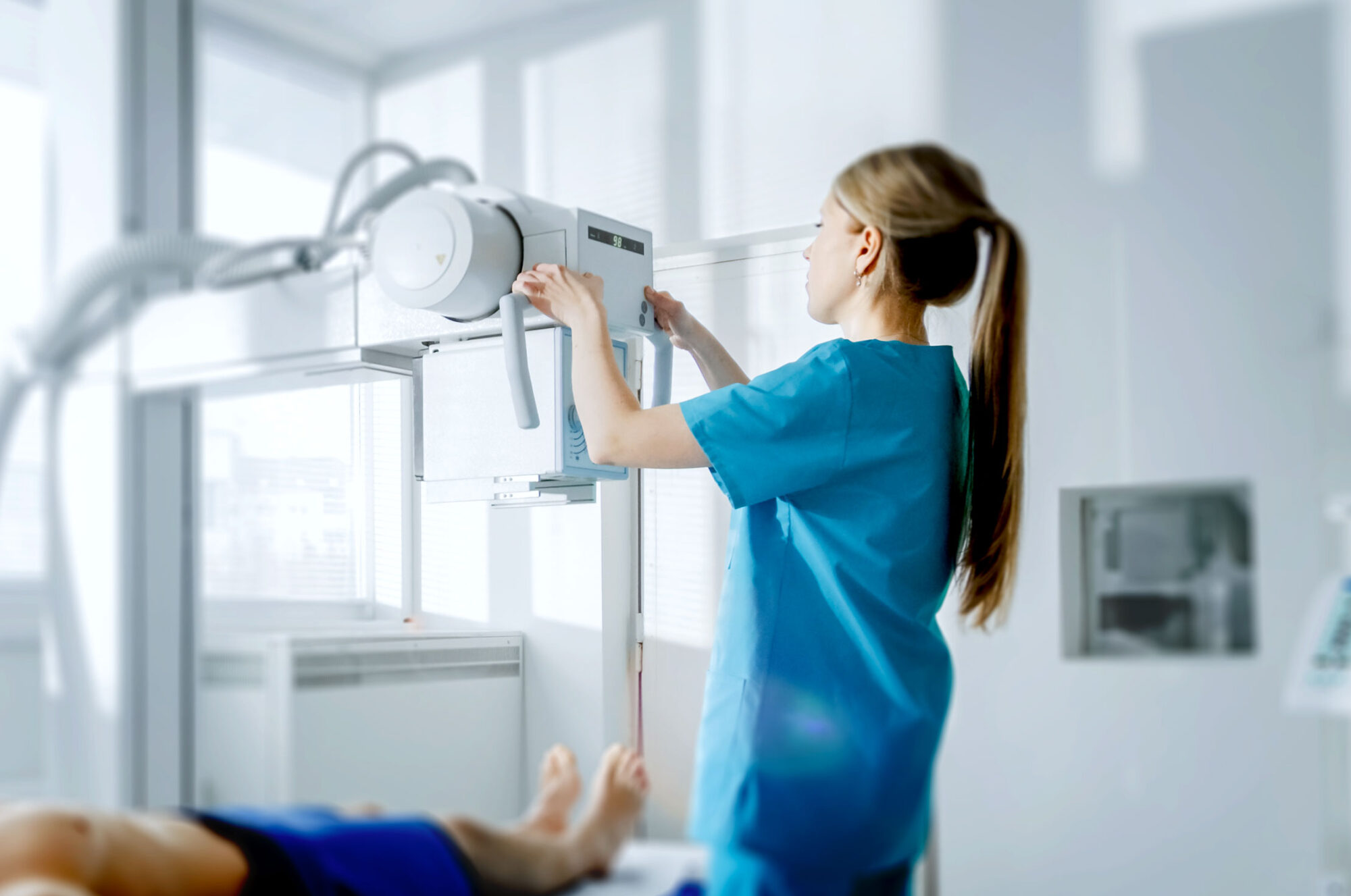 nurse using machine to take scan of patient