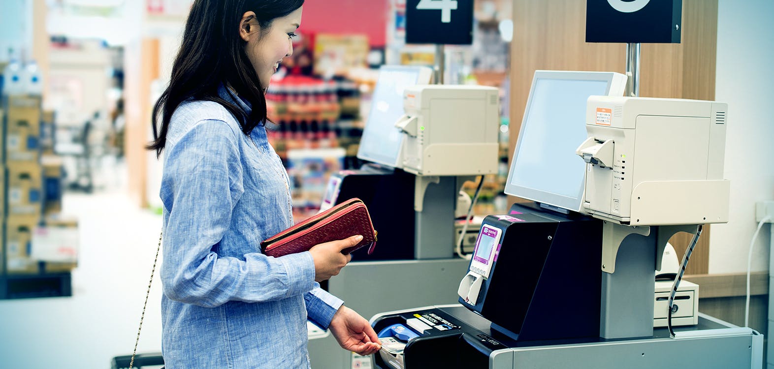 woman getting cash from a self checkout